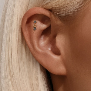 Macro view of gold s925 silver earring featuring black rutilated quartz on ear cartilage