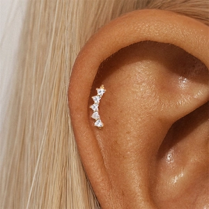 Macro shot of 925 silver gold-plated cartilage stud featuring five heart-shaped zircons