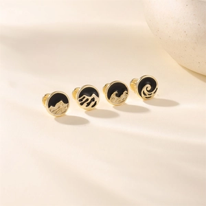 Détail de quatre clous d'oreilles en argent S925 doré avec motifs montagne et vague en émail