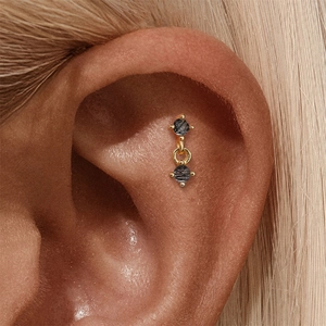 Detailed view of S925 silver ear piercing with black rutilated quartz in gold setting
