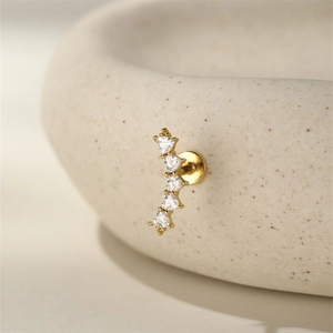 Macro detail of gold earring with five heart-shaped zircons and flat screw back