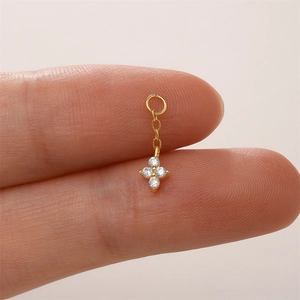 Dettaglio macro del ciondolo a croce in argento sterling S925 placcato oro con quattro pietre