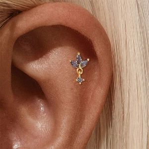 Detailopname van een S925 zilveren piercing met marquise regenboogstenen op het oor