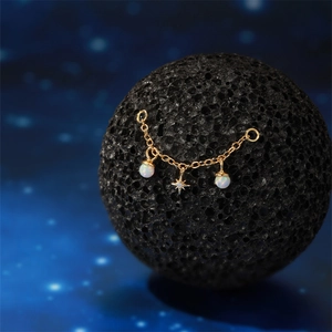 Detail of s925 gold chain earring with opal beads and star charm on celestial background