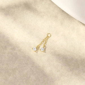 Dettaglio di orecchini placcati oro 18K con doppie catene lunghe e pendenti in zircone