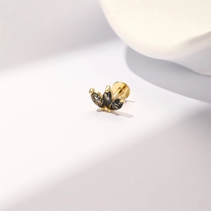 Detailed macro view of gold-plated silver labret earring with black marquise gemstones