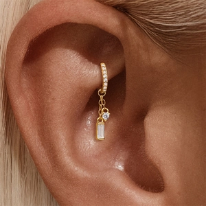 Dettaglio dell'orecchino ear cuff in oro 18K con zirconi e catenelle pendenti