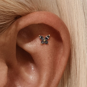 Macro shot of a golden butterfly ear stud with four dark grey rutilated quartz stones