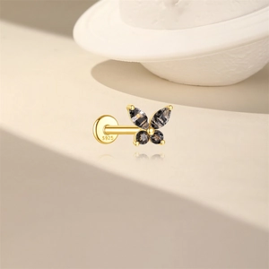 Macro shot of gold S925 silver butterfly stud earring with dark grey marquise crystals