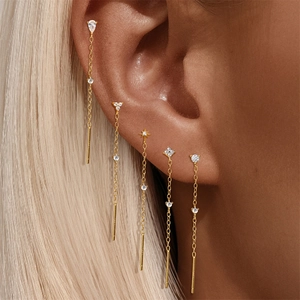 Close-up of gold s925 silver flower and heart threader earrings with white zircon accents