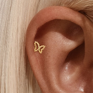 Close-up of a delicate gold beaded butterfly cartilage stud earring in S925 sterling silver