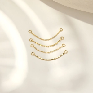 Close-up of four assorted gold-plated S925 silver jewelry chains with connector rings