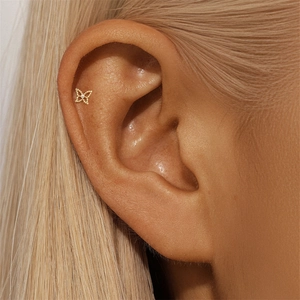 Close-up of a butterfly helix piercing earring with a zircon stone in gold finish