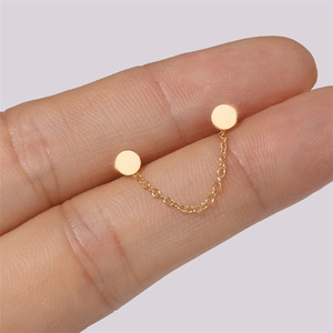 Minimalist gold double piercing stud earring connected by a fine delicate chain link