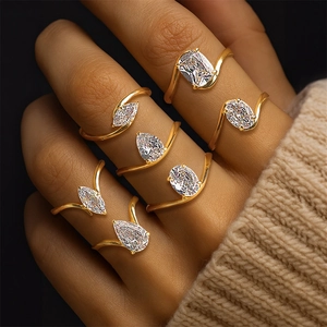 Detail of seven gold-plated rings with pear and oval zircon stones on a model's hand