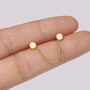 Detail of 925 sterling silver gold beaded chain earring connecting two minimalist studs