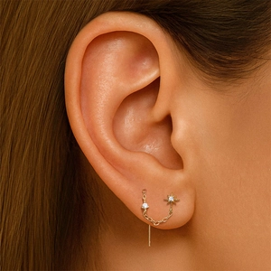 Macro shot of 925 silver gold star pendant earrings with diamonds on model ear
