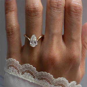 Macro shot of s925 silver pear cut zircon ring with rose gold finish on woman hand