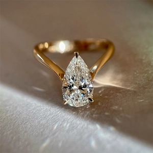 Macro detail of pear-cut zircon ring with three-prong setting on a gold band