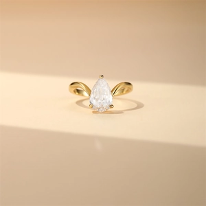 Detail of pear cut zircon ring with streamlined split band and elegant gold finish