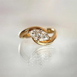 Detail of s925 silver ring with marquise-cut zircon in a golden bypass setting