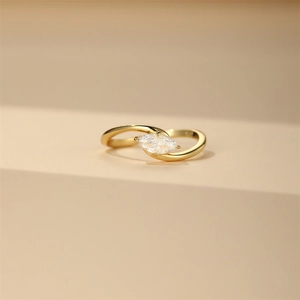 Macro shot of gold bypass ring with marquise-cut cubic zirconia in a prong setting