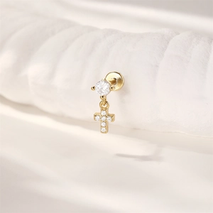 Nahaufnahme eines goldenen S925 Sterling Silber Kreuz-Piercings mit funkelndem Zirkonia
