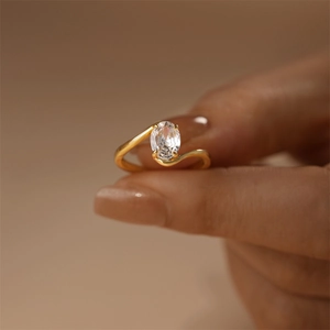 Macro view of a gold-plated ring featuring a large oval cubic zirconia in a 4-prong setting