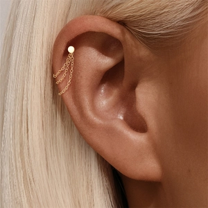 Close-up of gold cartilage cuff earring with three minimalist dangling curb chains