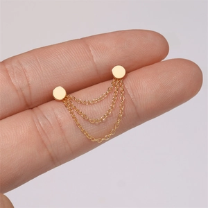 Detailed view of 925 silver golden triple-layered chain earrings held in hand
