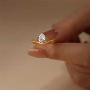 Detailed view of s925 silver ring featuring a pear-shaped zircon on a gold wavy band