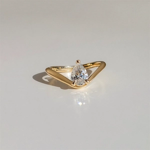 Macro detail of pear-cut zircon set in 18K gold V-shaped sterling silver ring band