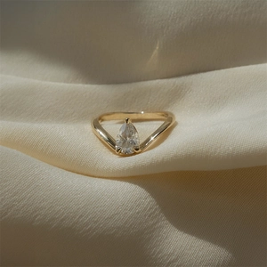 Detailed view of a pear-cut zircon stone on a V-shaped S925 silver gold-plated ring band