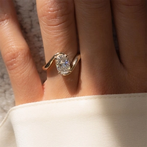 Detailed view of a gold bypass ring featuring a large cushion cut rectangular gemstone