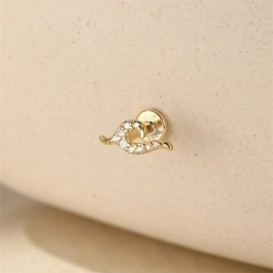 Macro detail of S925 sterling silver stamp on golden wavy stud earring with zircons