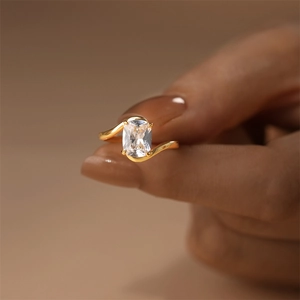 Macro view of gold-plated silver ring featuring a large rectangular zircon and curved band