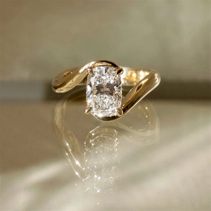 Detailed macro view of sparkling cushion-cut zirconia on asymmetrical gold-plated ring