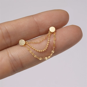 Detailed view of gold multi-layer tassel earrings with bead and flat chain links