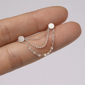 Detail of silver S925 sterling silver triple layered chain earring held by hand