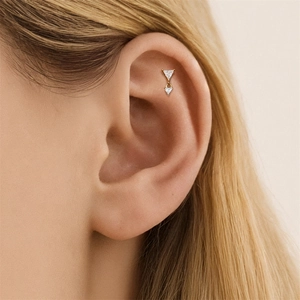 Detail von s925 Silber Gold Ohrpiercing mit zwei dreieckigen CZ-Steinen auf flachem Knorpel