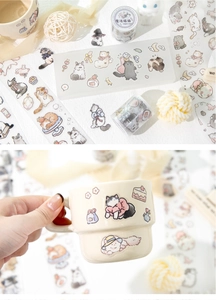 Close-up of cute cat PET tape stickers on a white mug for DIY journal decoration