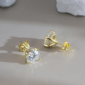 Detalle de pendientes de moissanita en plata de ley 925 dorada con engaste de cuatro garras