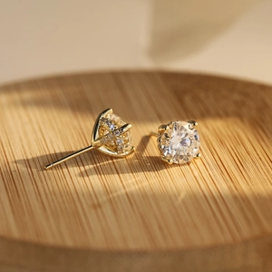 Detalle del pendiente de plata 925 bañada en oro con engaste de diamante en forma de X