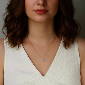 Primo piano di un'elegante collana con ciondolo in moissanite dorata indossata da modella