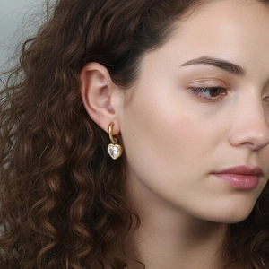Elegante vergoldete Herz-Ohrhänger mit Kristallsteinen an einem weiblichen Model