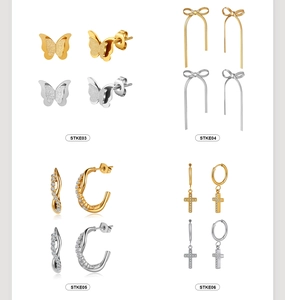 Detail view of cross hoop and butterfly earrings set in gold and silver plating