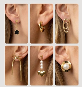 Detailed close-up of six gold-plated earrings with zircon and pearl inlays on ear