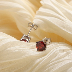 Gros plan sur des boucles d'oreilles en argent avec grenat rouge et poinçon S925 gravé