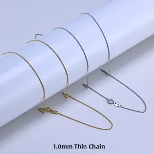 Macro shot of 1.0mm gold and silver 925 sterling silver curb chains with lobster clasps