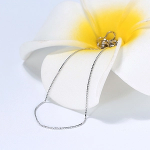 Polished S925 sterling silver 1.0mm box chain necklace draped on a tropical flower